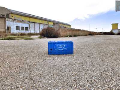 Accediamo sullo spazio esterno alla fabbrica: una distesa di cemento dove giace una vuota cassetta azzurra di birra  e grazie a un varco entriamo nel primo capannone, quello pi� piccolo